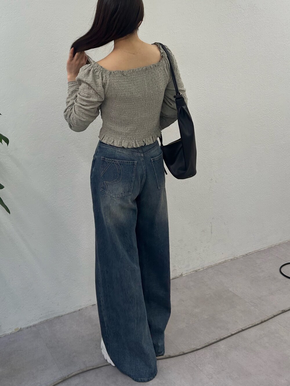 グリーン系のシャツ/ブラウス、グレー系のデニムパンツ、ブラック系のバックパック/リュックを着用したレディースの冬コーディネートの2枚目の写真