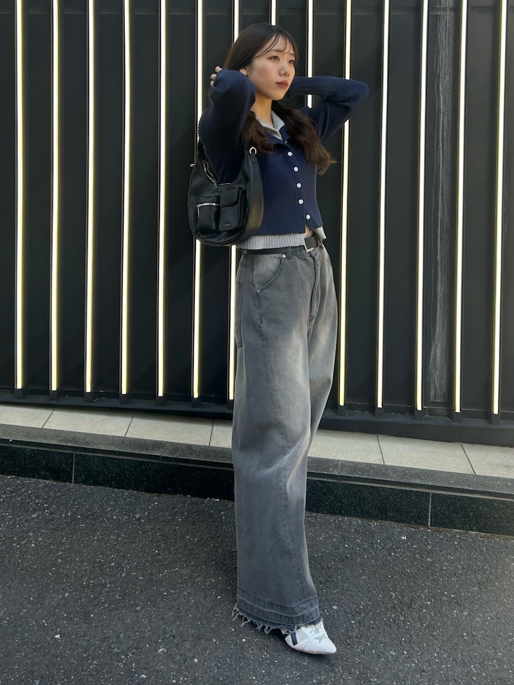 グレー系のデニムパンツ、ホワイト系のサンダル、レッド系のニット/セーターを着用したレディースの冬コーディネートの2枚目の写真