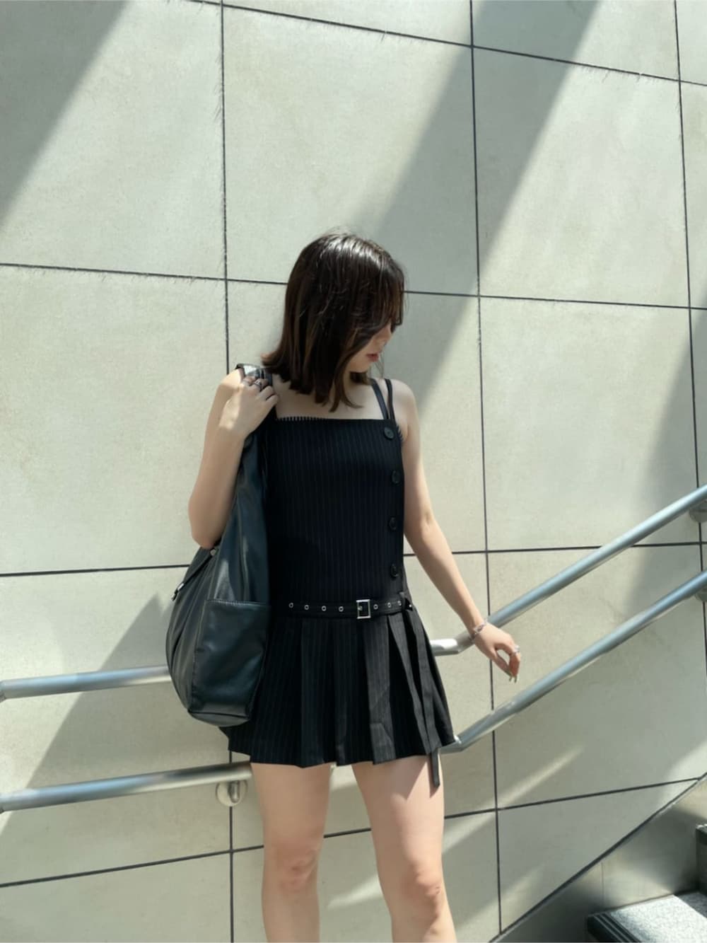 ブラック系のワンピースを着用したレディースの夏コーディネートの2枚目の写真