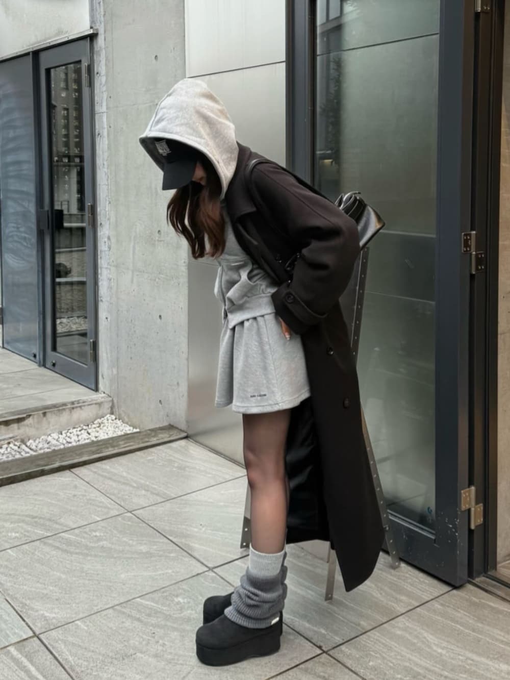 ブラック系のその他アウター、グレー系のパーカー、グレー系のスカートを着用したレディースの冬コーディネートの3枚目の写真