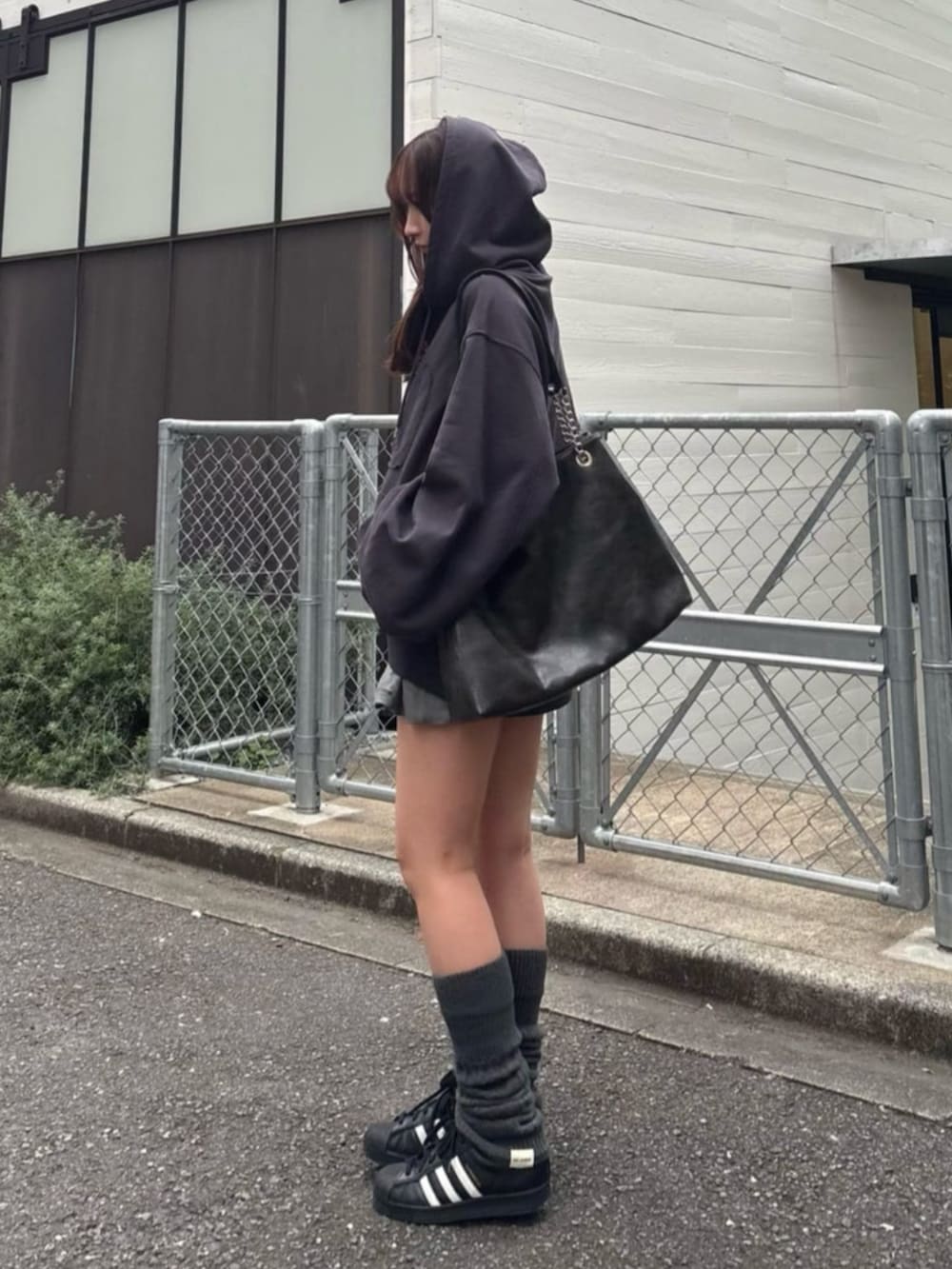 グレー系のパーカー、グレー系のスカート、グレー系のレッグウォーマーを着用したレディースの秋コーディネートの3枚目の写真