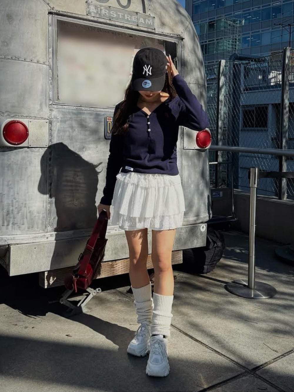 グリーン系のTシャツ/カットソー、レッド系のショルダーバッグ、ホワイト系のスカートを着用したレディースの冬コーディネートの5枚目の写真