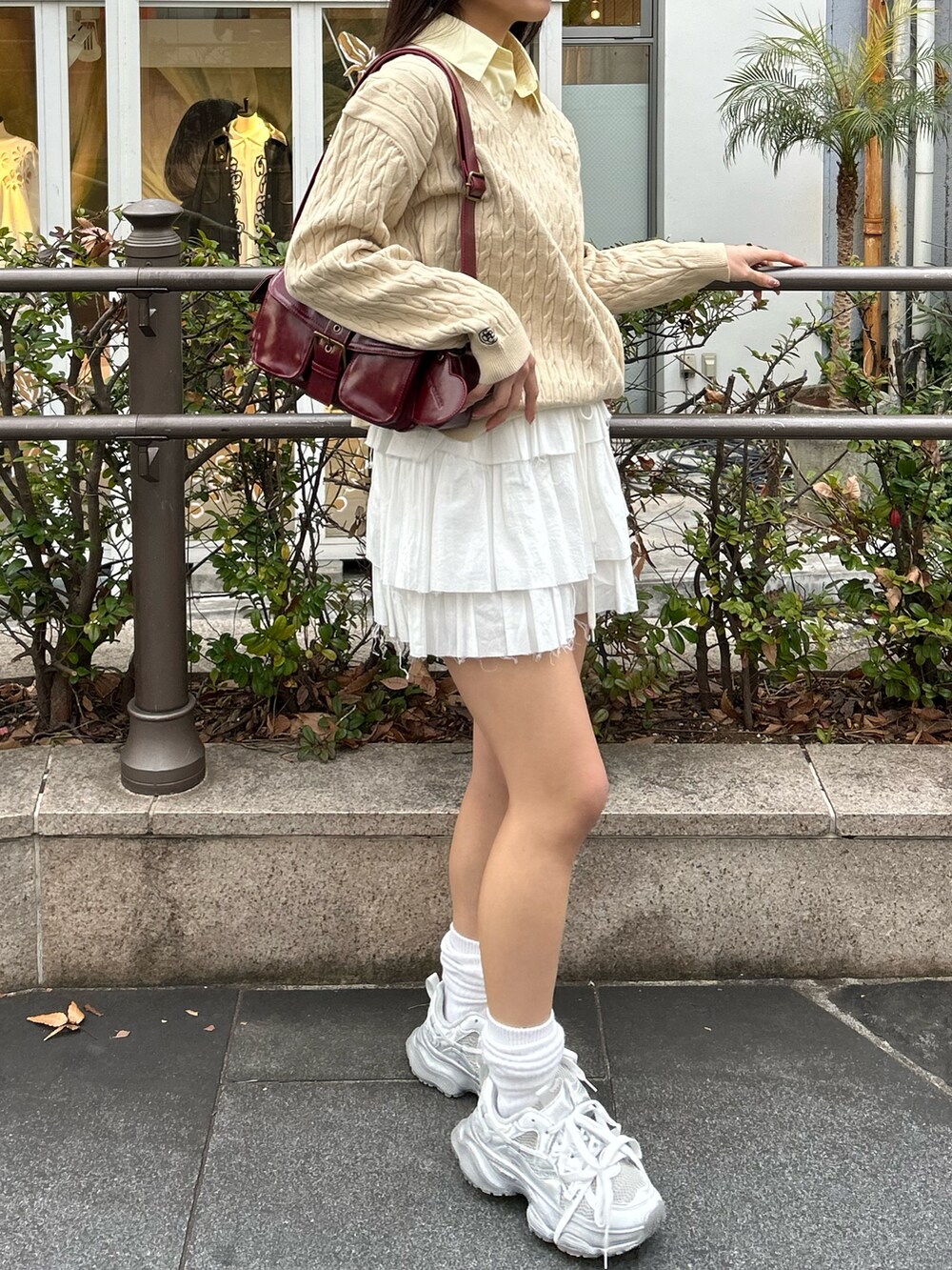 ベージュ系のニット/セーター、ホワイト系のスカート、シルバー系のスニーカーを着用したレディースの冬コーディネートの3枚目の写真