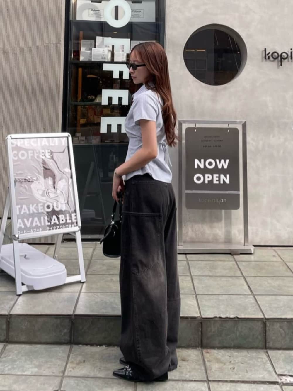 ブラック系のデニムパンツ、ブルー系のシャツ/ブラウス、シルバー系のネックレスを着用したレディースの春コーディネートの2枚目の写真