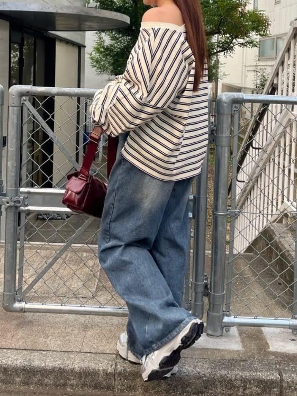 ブルー系のデニムパンツ、シルバー系のスニーカー、ホワイト系のTシャツ/カットソーを着用したレディースの冬コーディネートの2枚目の写真