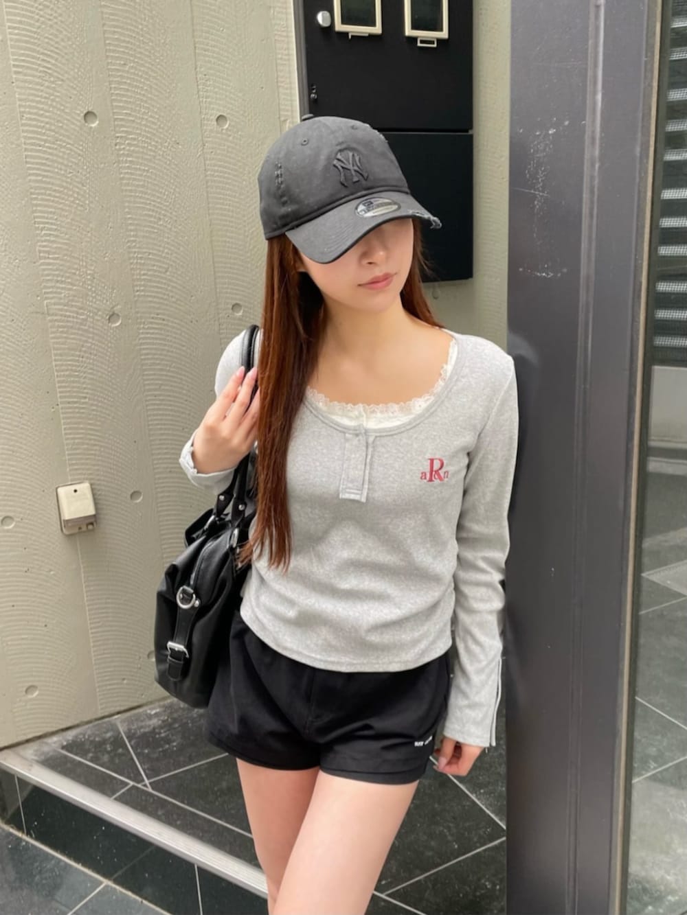 グレー系のTシャツ/カットソー、ブラック系のショルダーバッグを着用したレディースの春コーディネートの2枚目の写真