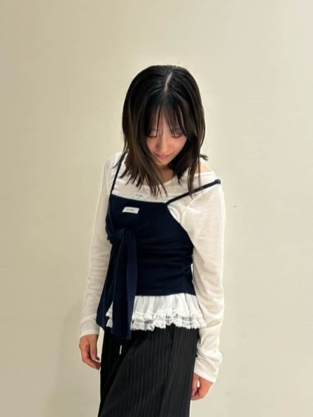 ブラック系のスラックス、ホワイト系のTシャツ/カットソー、ブルー系のキャミソールを着用したレディースの秋コーディネートの2枚目の写真