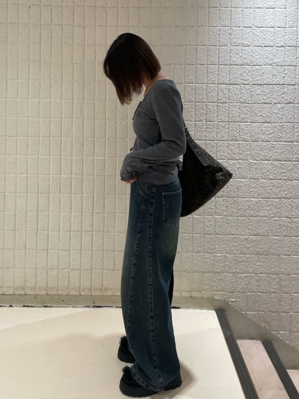 ブルー系のデニムパンツ、ブラック系のブルゾン、ブラック系のその他シューズを着用したレディースの秋コーディネートの3枚目の写真