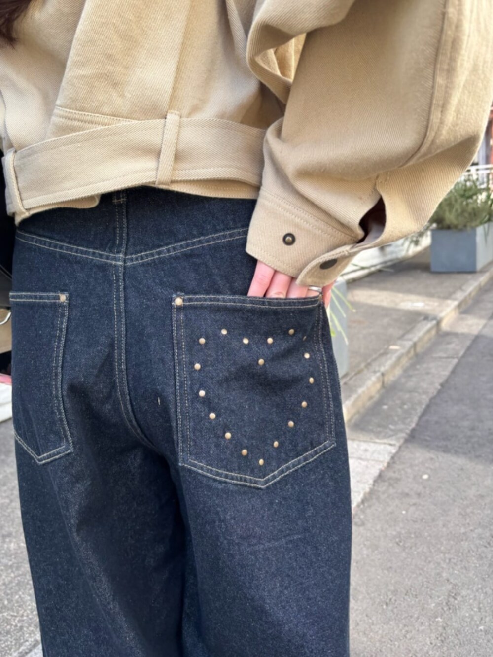 ブルー系のデニムパンツ、ブラック系のキャミソール、ベージュ系のその他アウターを着用したレディースの冬コーディネートの4枚目の写真