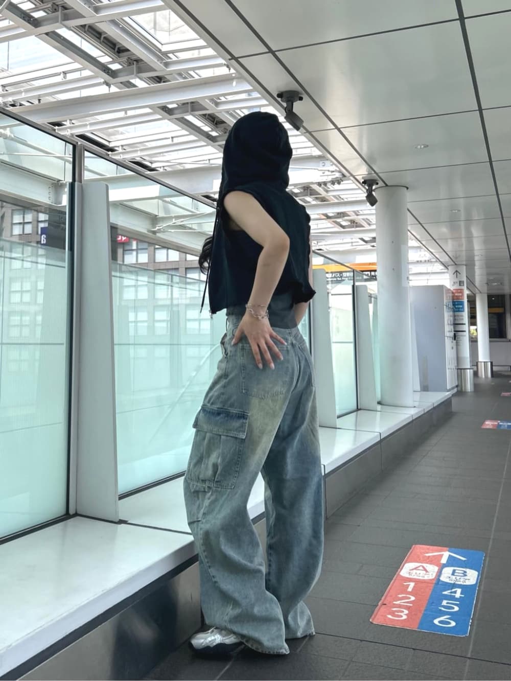 グレー系のキャミソール、ブラック系のTシャツ/カットソー、ブルー系のデニムパンツを着用したレディースの夏コーディネートの4枚目の写真