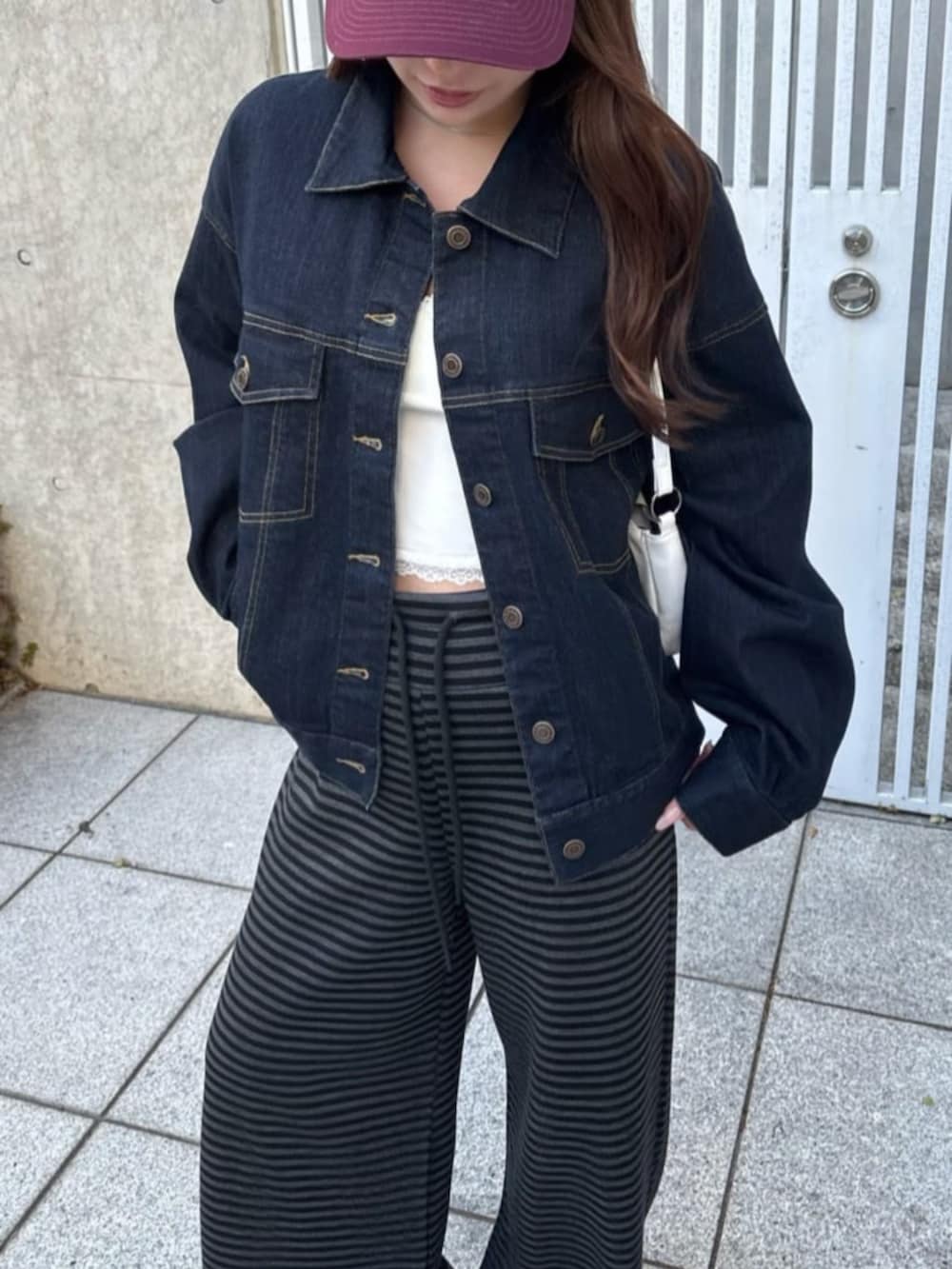 ブルー系のデニムジャケット、グレー系のその他パンツを着用したレディースの春コーディネートの3枚目の写真