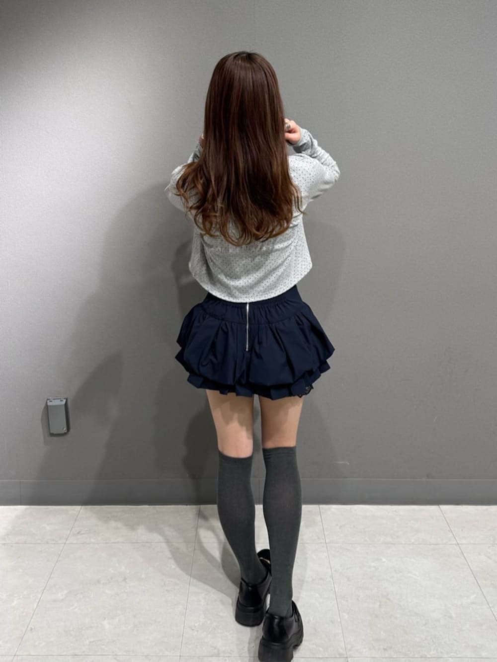 ブルー系のスカート、グレー系のカーディガン/ボレロを着用したレディースの冬コーディネートの3枚目の写真