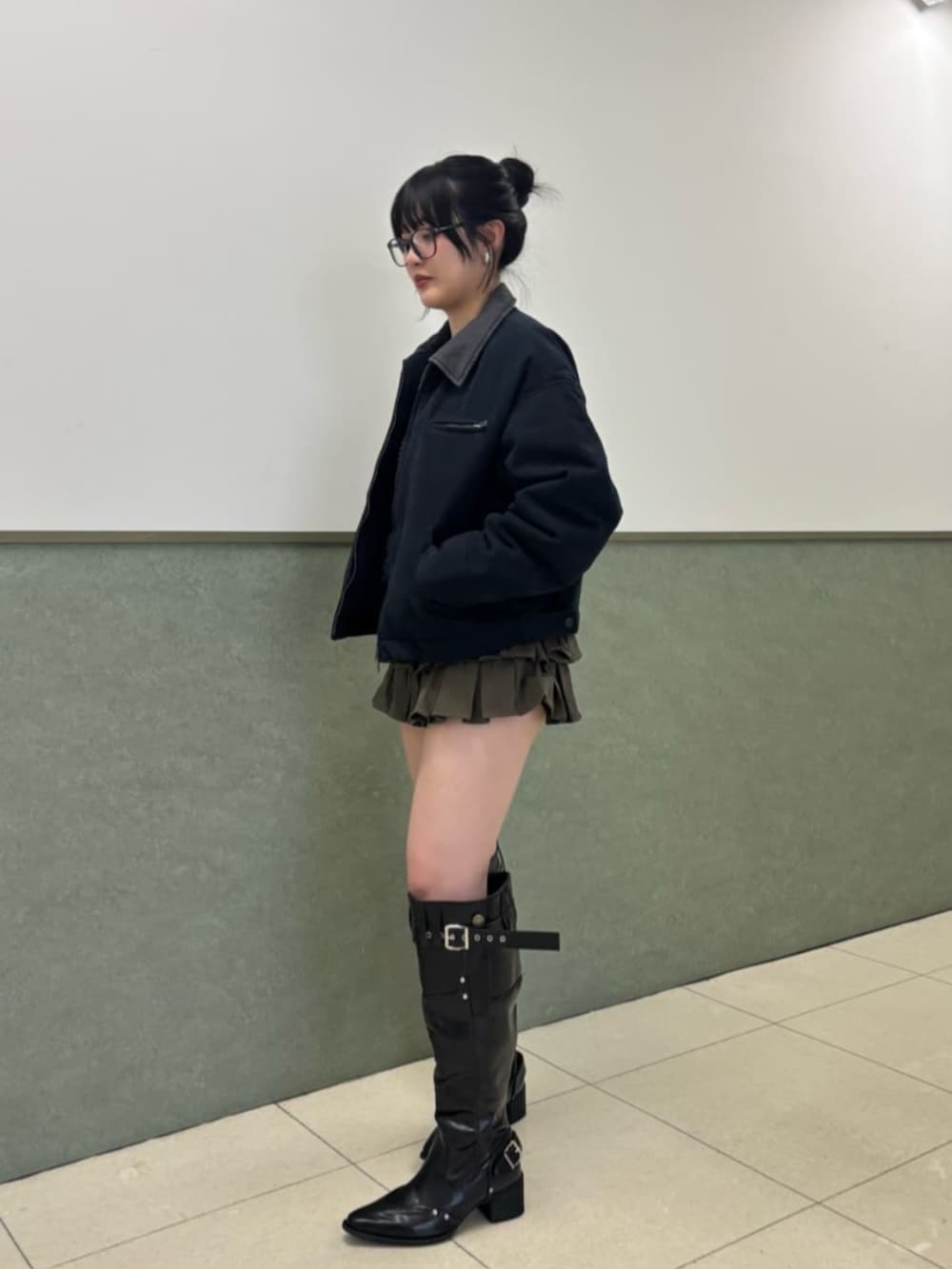 ブルー系のブルゾン、ブラウン系のスカート、ブラック系のブーツを着用したレディースの冬コーディネートの2枚目の写真