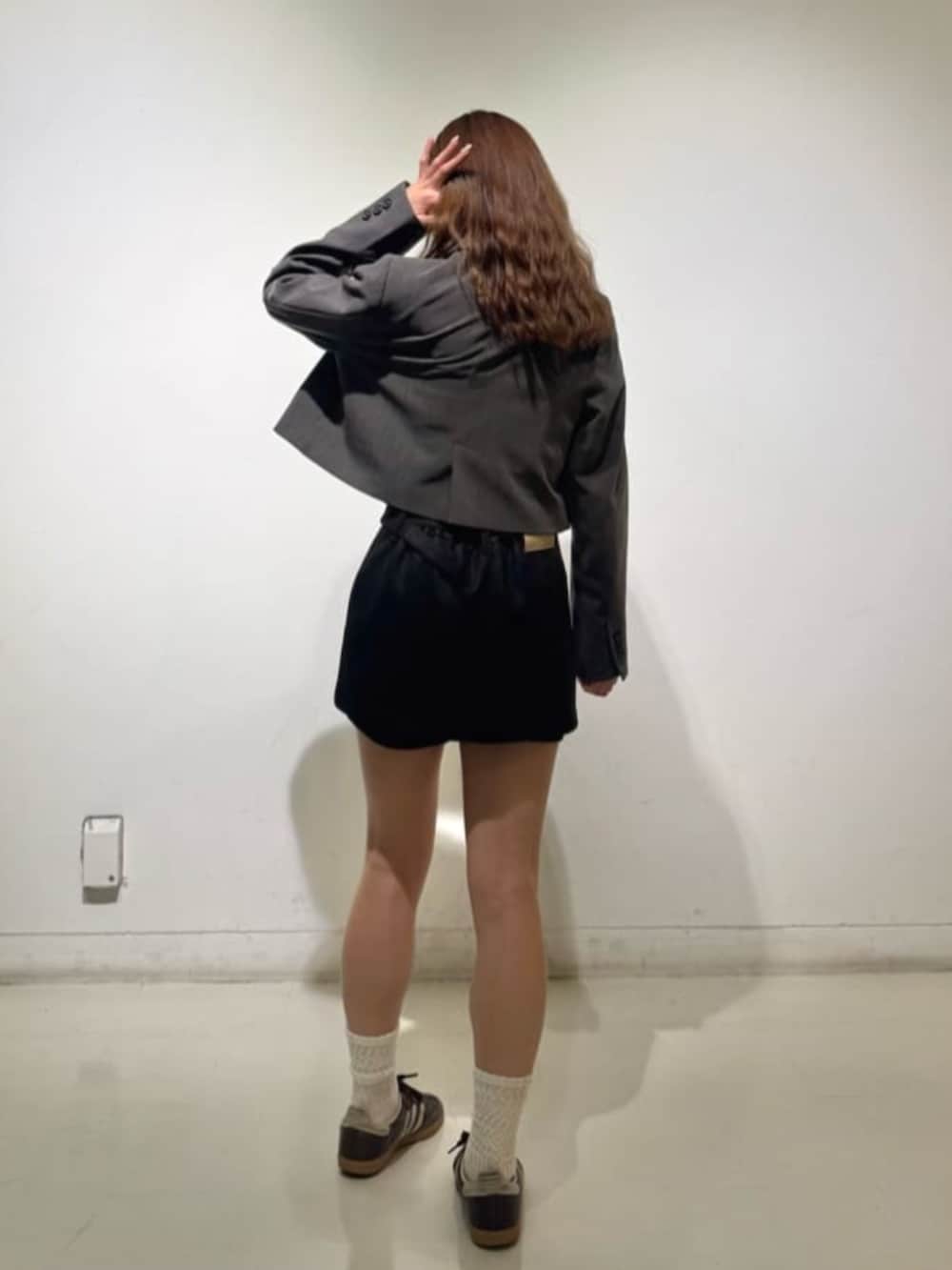 グレー系のその他アウター、ブラック系のスカートを着用したレディースの秋コーディネートの2枚目の写真