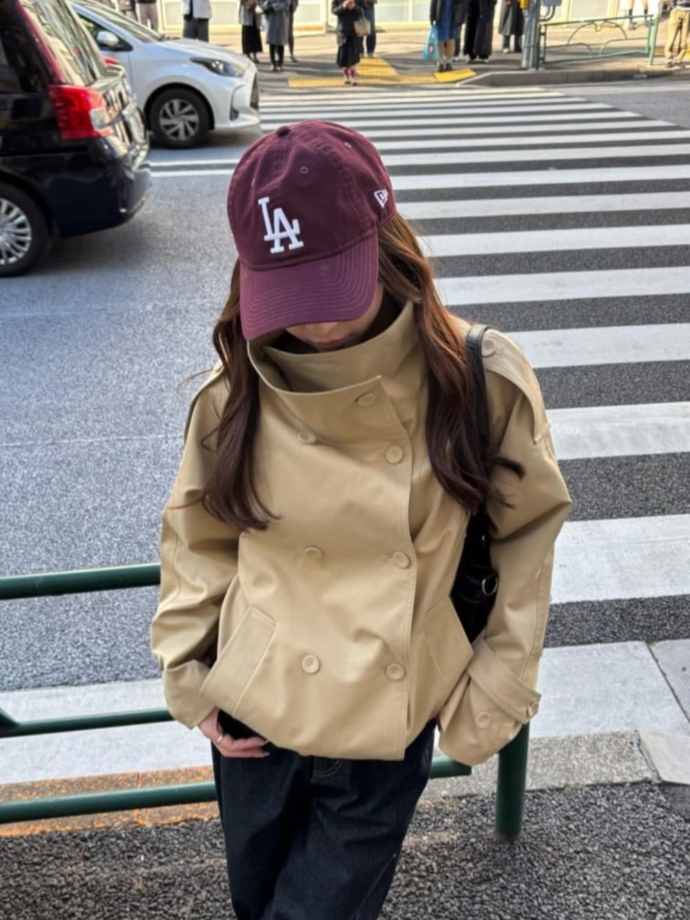 ベージュ系のトレンチコート、ブルー系のデニムパンツを着用したレディースの冬コーディネートの2枚目の写真