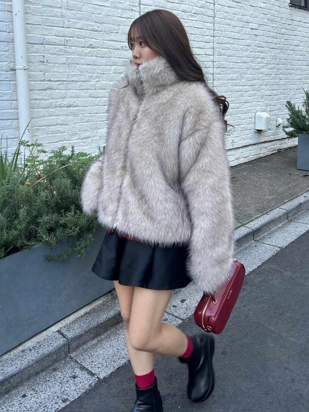 ブラック系のその他パンツ、レッド系のボストンバッグ、ブラック系のブーツを着用したレディースの冬コーディネートの2枚目の写真