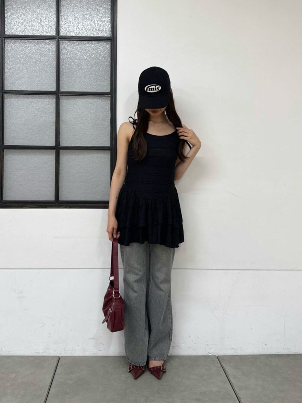 ブルー系のデニムパンツ、ブラック系のパーカー、ブラック系のワンピースを着用したレディースの春コーディネートの4枚目の写真