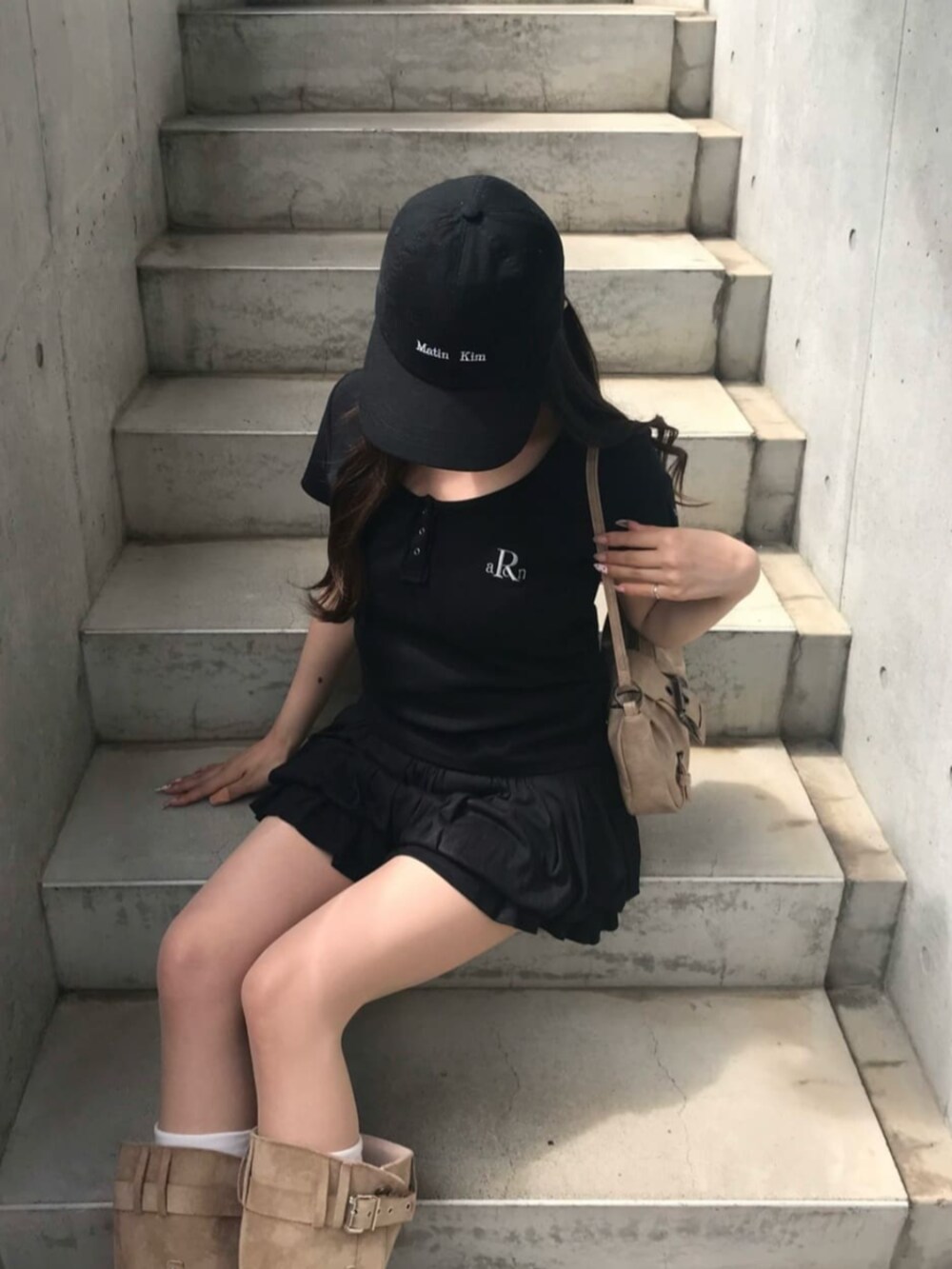 ブラック系のTシャツ/カットソー、ブラック系のスカートを着用したレディースの春コーディネートの2枚目の写真