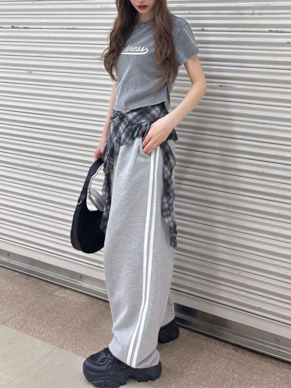 ブラック系のキャミソール、ブラウン系のデニムパンツを着用したレディースの春コーディネートの4枚目の写真