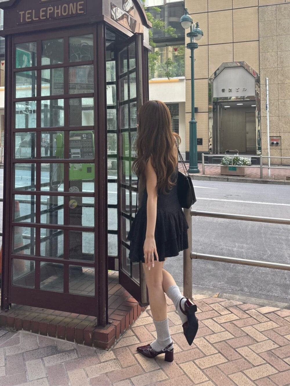ブラック系のワンピースを着用したレディースの春コーディネートの3枚目の写真