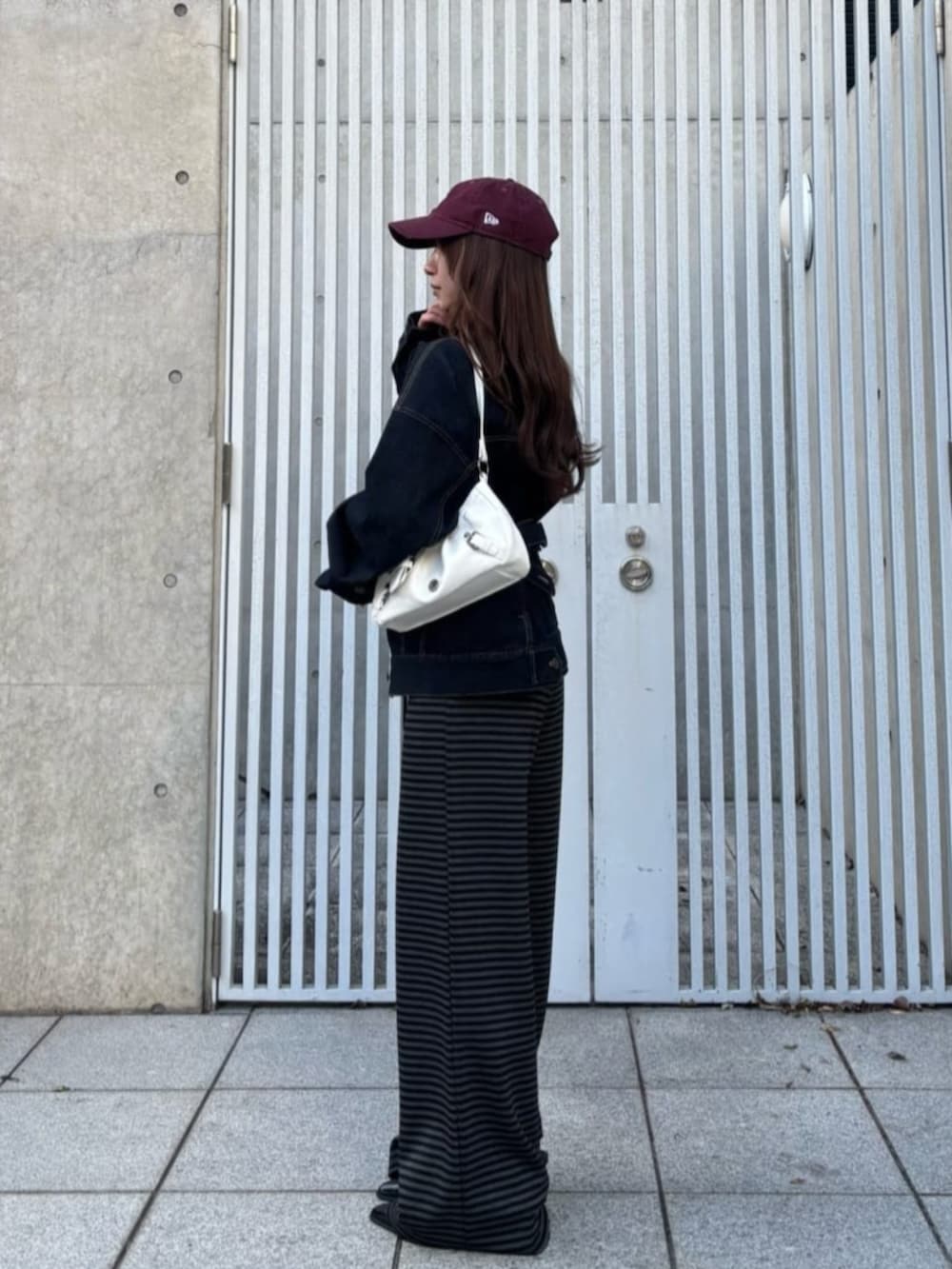 ブルー系のデニムジャケット、グレー系のその他パンツを着用したレディースの春コーディネートの2枚目の写真