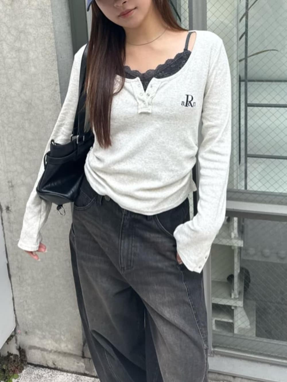 ブラック系のデニムパンツ、ホワイト系のTシャツ/カットソー、グレー系のキャミソールを着用したレディースの春コーディネートの2枚目の写真