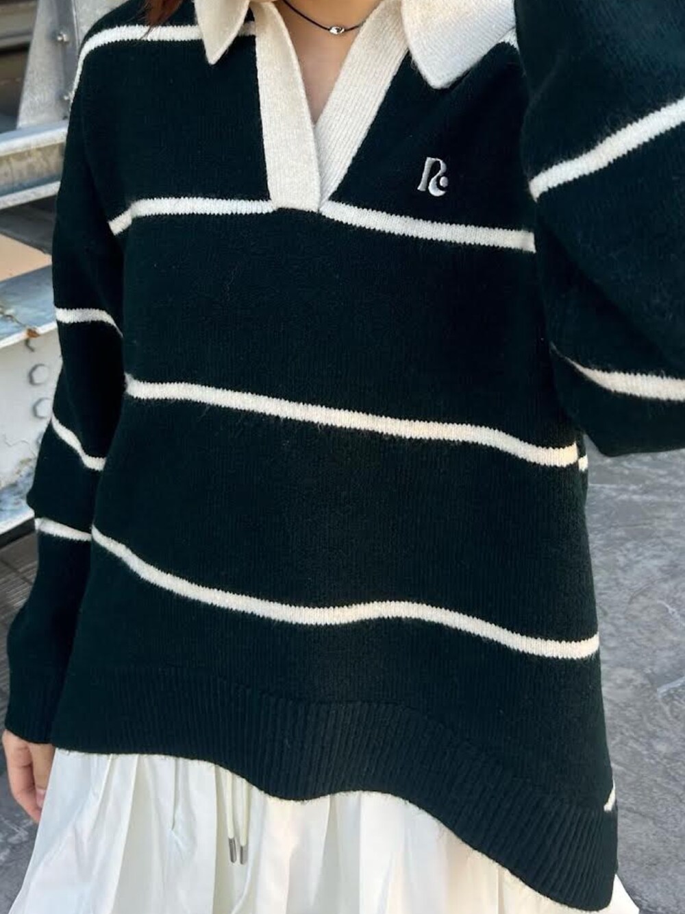 グリーン系のニット/セーター、ホワイト系のスカートを着用したレディースの冬コーディネートの2枚目の写真