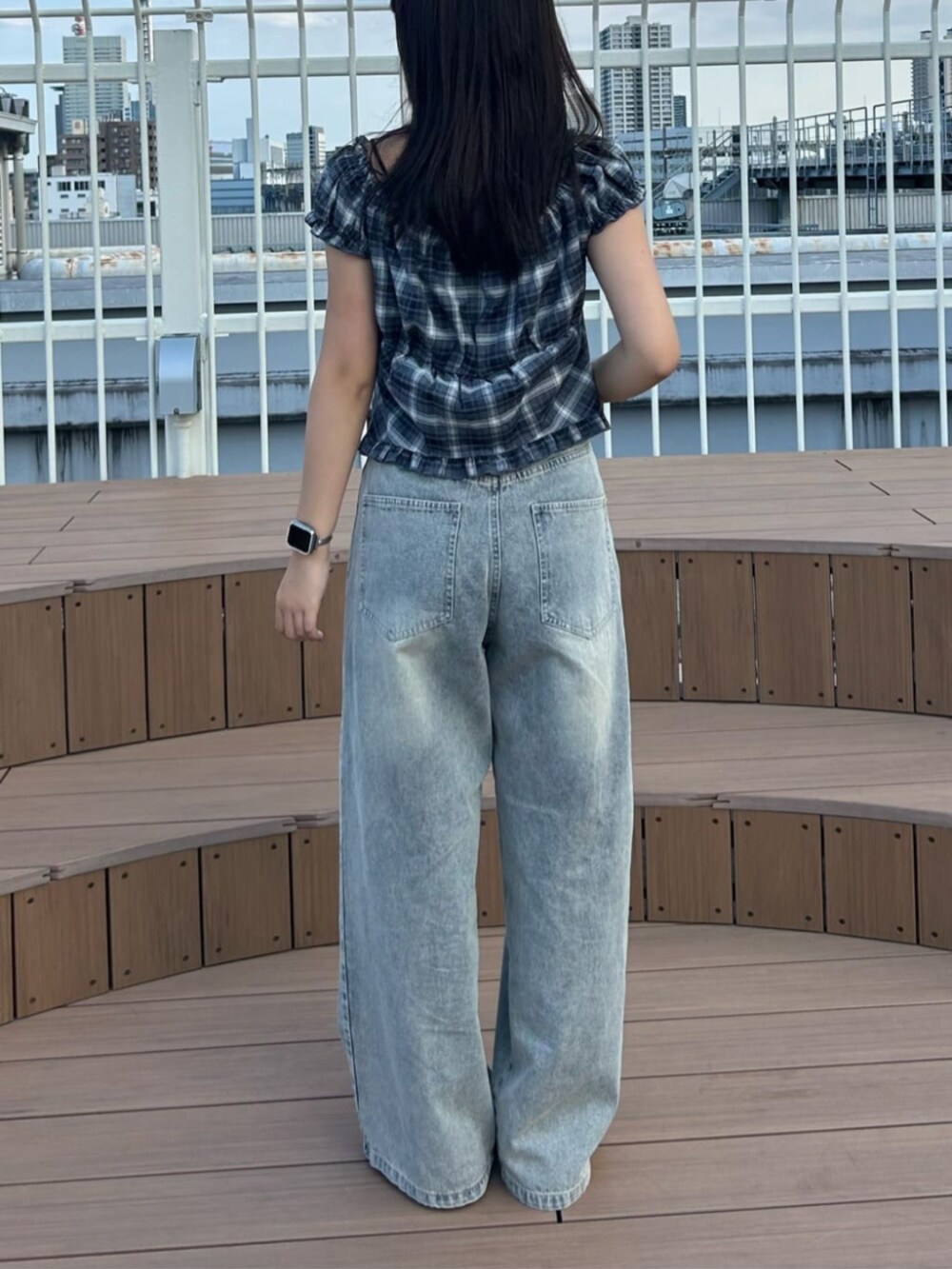 ブルー系のデニムパンツ、ブラック系のシャツ/ブラウスを着用したレディースの秋コーディネートの3枚目の写真