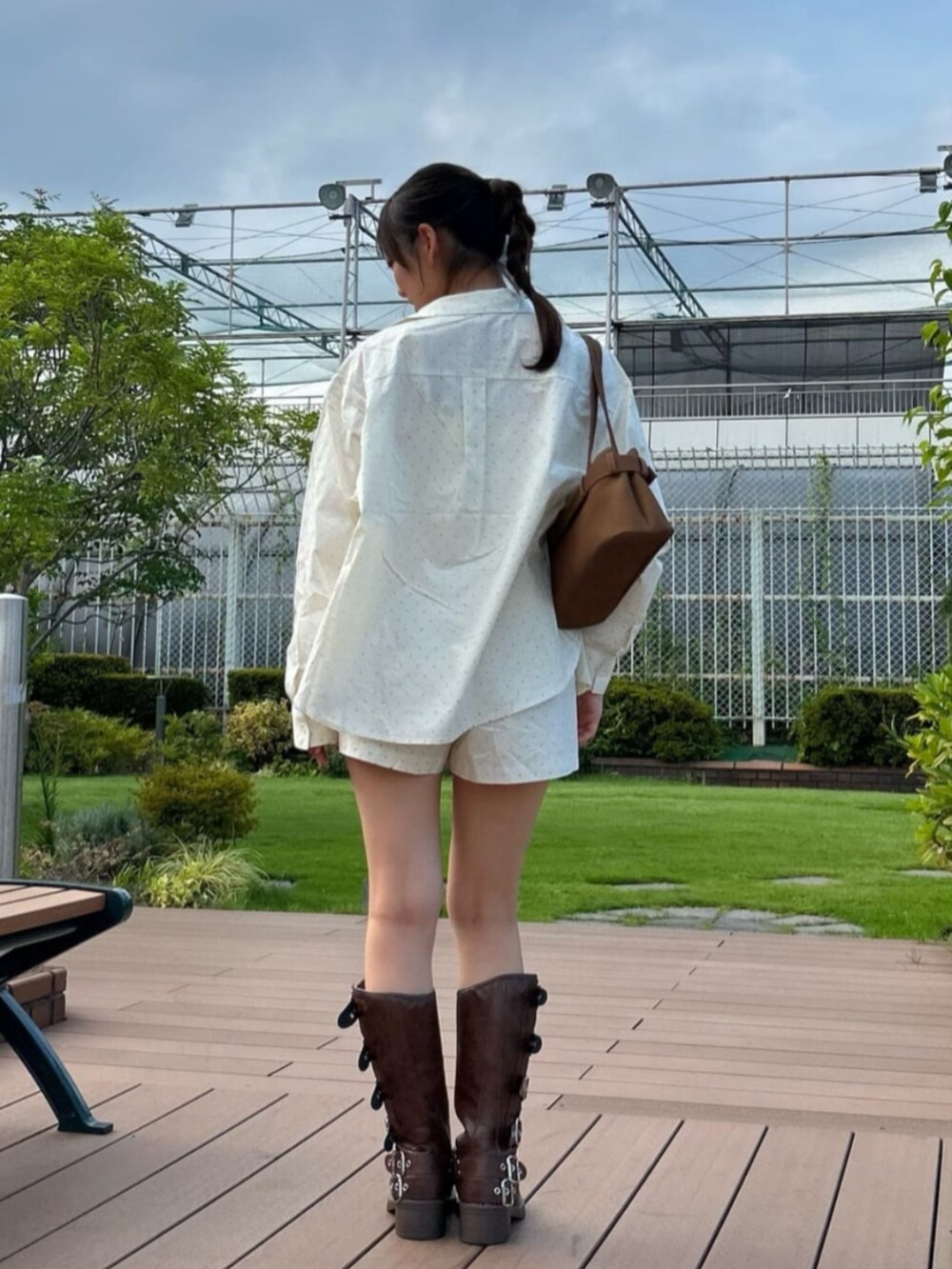 ブラウン系のブーツ、ホワイト系のキャミソール、ホワイト系のシャツ/ブラウスを着用したレディースの秋コーディネートの3枚目の写真