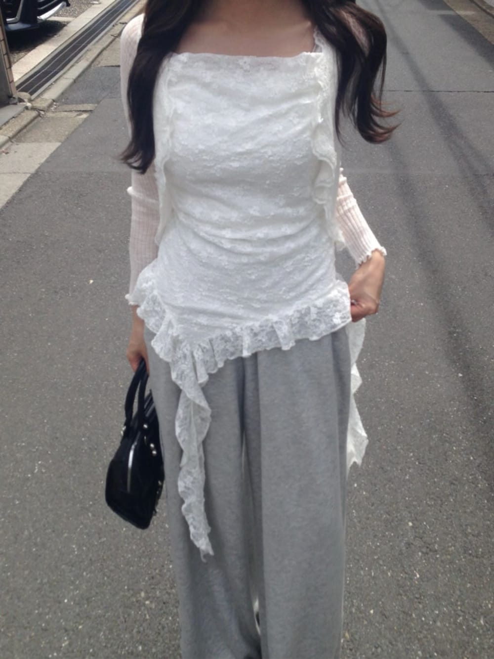 グレー系のスウェットパンツ、ブラック系のショルダーバッグ、ホワイト系のカーディガン/ボレロを着用したレディースの春コーディネートの2枚目の写真