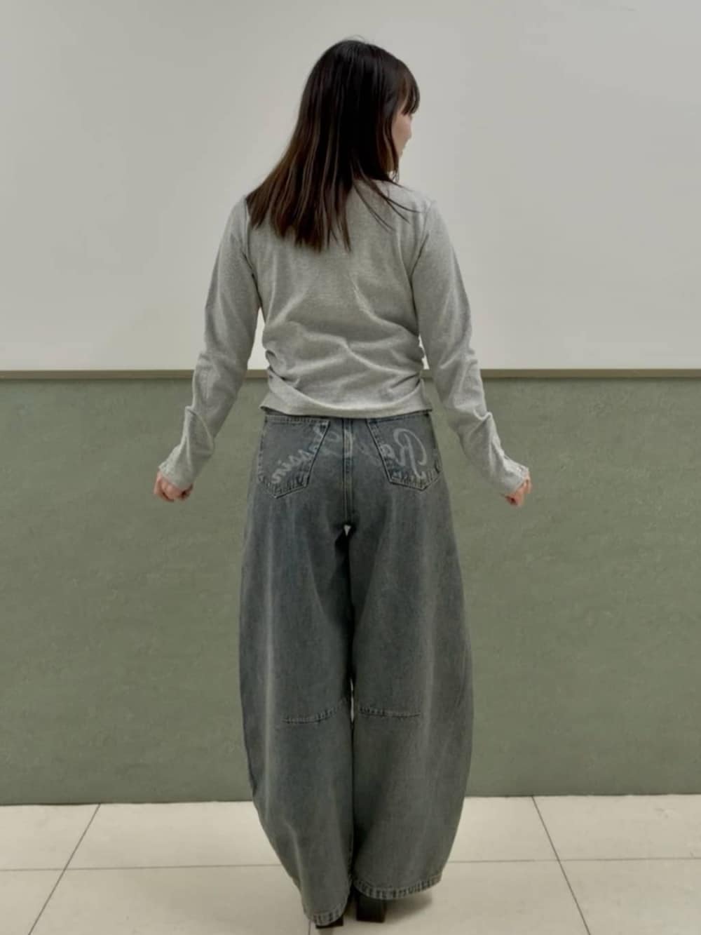 グレー系のTシャツ/カットソー、ブルー系のデニムパンツを着用したレディースの春コーディネートの2枚目の写真