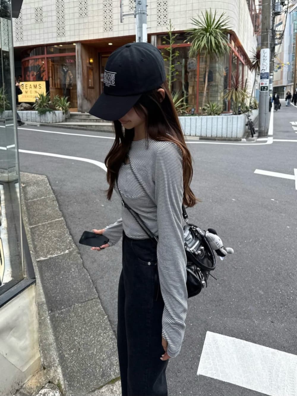 グレー系のTシャツ/カットソー、ブラック系のデニムパンツ、ブラック系のショルダーバッグを着用したレディースの春コーディネートの3枚目の写真