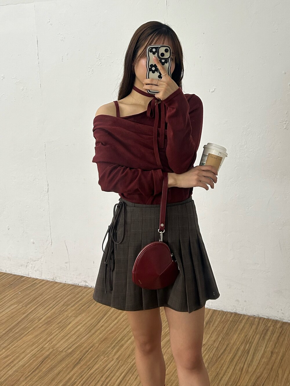 レッド系のニット/セーター、ブラウン系のスカートを着用したレディースの秋コーディネートの2枚目の写真