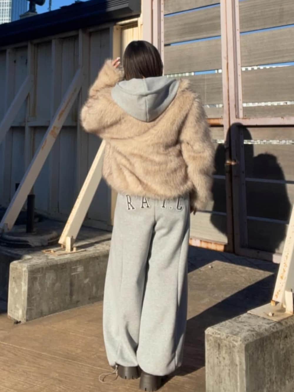 グレー系のスウェットパンツ、グレー系のパーカー、ブラウン系のスリッポンを着用したレディースの冬コーディネートの2枚目の写真