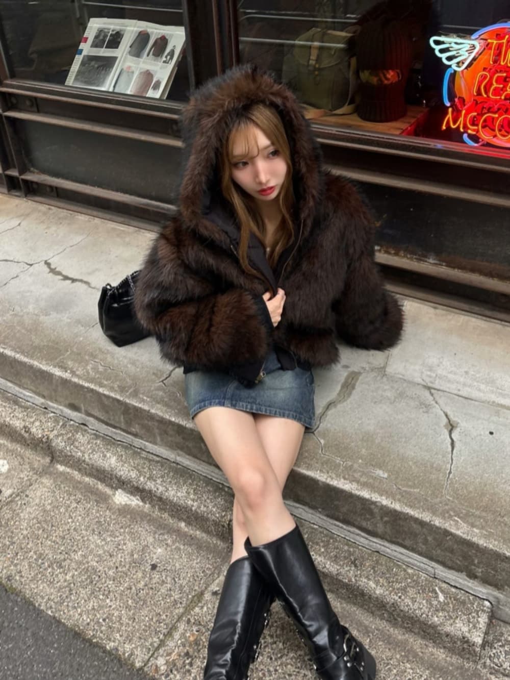 ブルー系のスカート、ブラウン系のブルゾンを着用したレディースの秋コーディネートの2枚目の写真