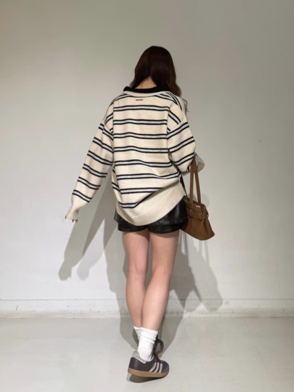 ホワイト系のニット/セーター、ブラウン系のスカートを着用したレディースの秋コーディネートの2枚目の写真