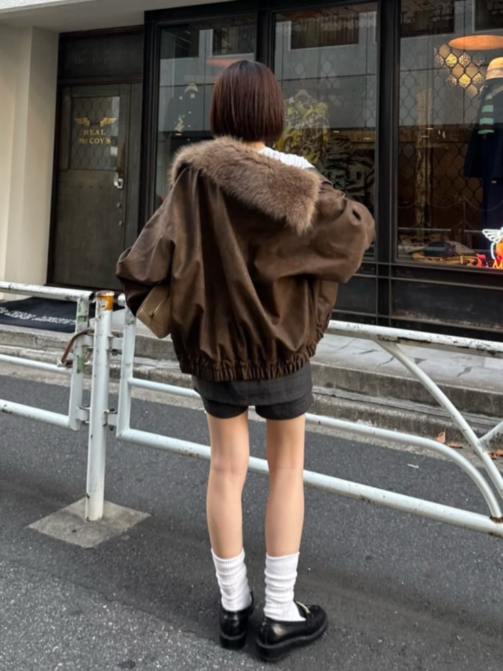 ベージュ系のブルゾン、ブラック系のスカート、イエロー系のトートバッグを着用したレディースの秋コーディネートの3枚目の写真