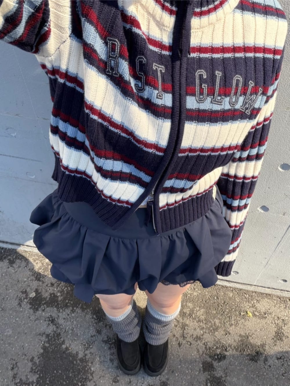 ブルー系のスカート、ブルー系のニット/セーター、グレー系のレッグウォーマーを着用したレディースの冬コーディネートの2枚目の写真