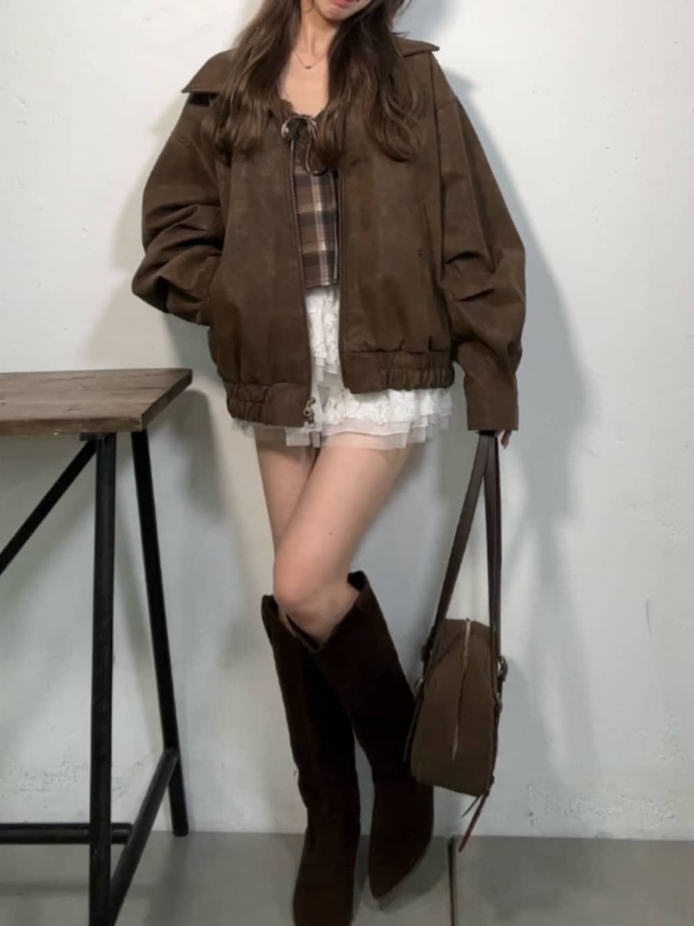 ブラウン系のブーツ、ブラウン系のトートバッグ、ホワイト系のスカートを着用したレディースの秋コーディネートの2枚目の写真