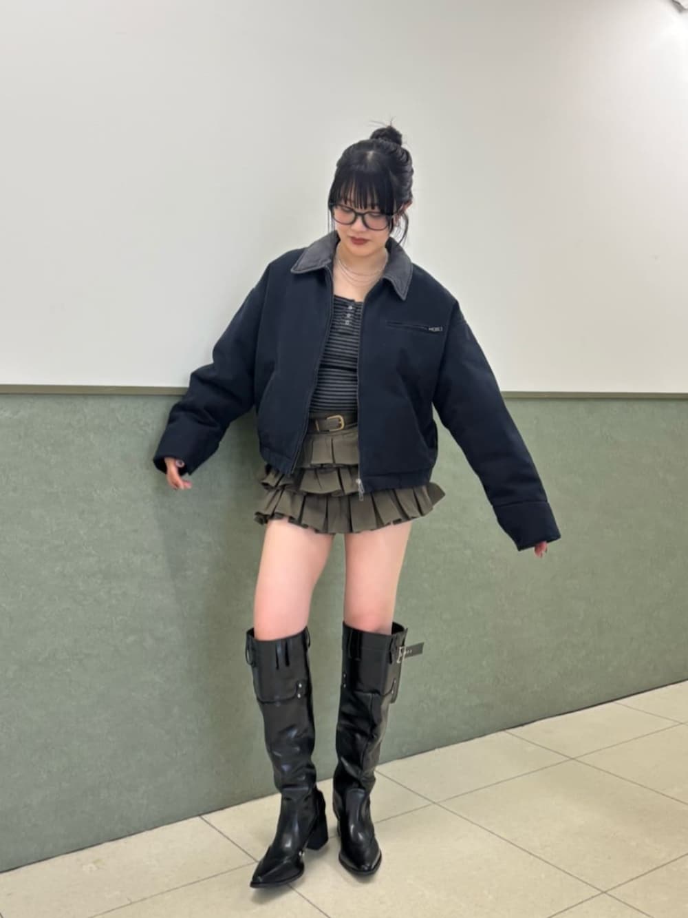 ブルー系のブルゾン、ブラウン系のスカート、ブラック系のブーツを着用したレディースの冬コーディネートの3枚目の写真