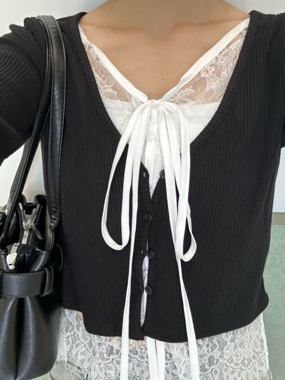 ブルー系のデニムパンツ、ブラック系のショルダーバッグ、ブラック系のカーディガン/ボレロを着用したレディースの秋コーディネートの3枚目の写真