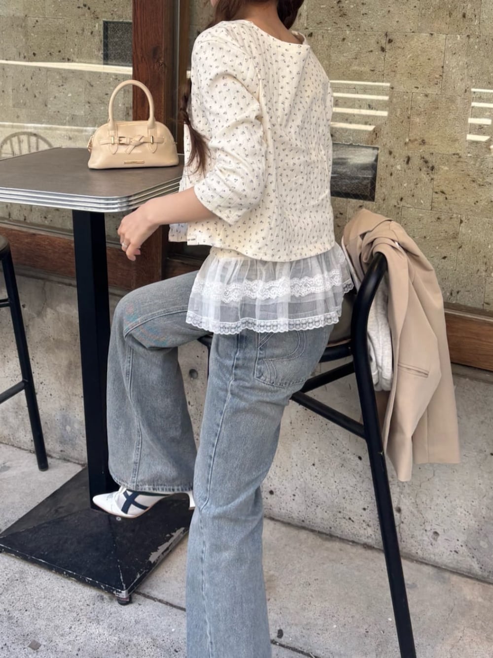 ブルー系のデニムパンツ、ホワイト系のサンダル、ホワイト系のカーディガン/ボレロを着用したレディースの春コーディネートの4枚目の写真