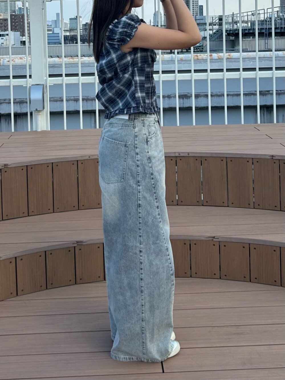 ブルー系のデニムパンツ、ブラック系のシャツ/ブラウスを着用したレディースの秋コーディネートの2枚目の写真