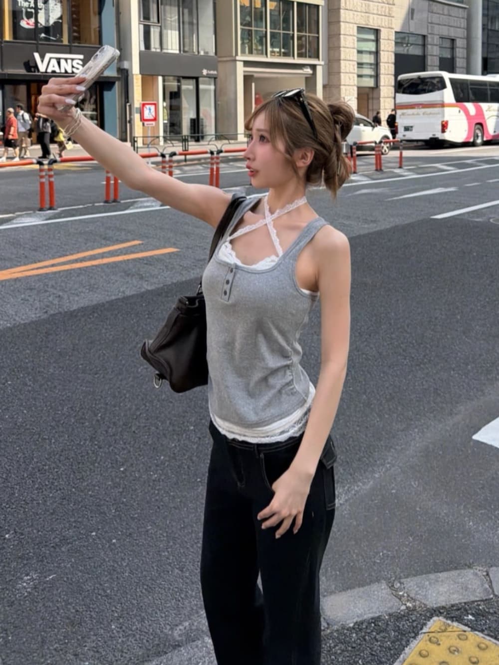 ブラウン系のショルダーバッグ、グレー系のTシャツ/カットソー、ブラック系のデニムパンツを着用したレディースの夏コーディネートの2枚目の写真