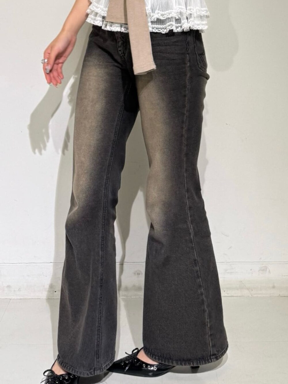 ホワイト系のキャミソール、ブラウン系のデニムパンツ、ブラック系のその他シューズを着用したレディースの秋コーディネートの2枚目の写真