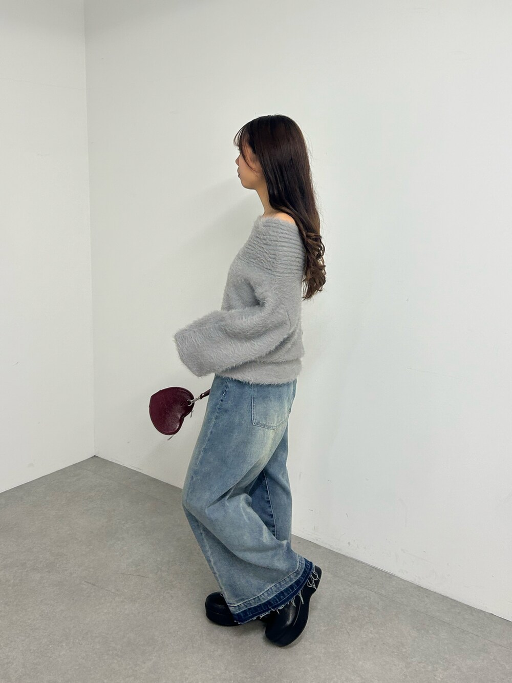 グレー系のニット/セーター、ブルー系のデニムパンツを着用したレディースの冬コーディネートの3枚目の写真