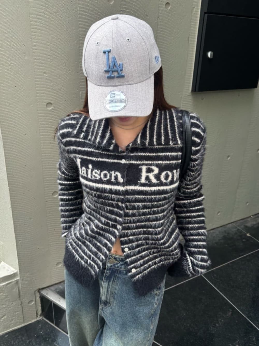 ブルー系のデニムパンツ、ブラック系のニット/セーターを着用したレディースの冬コーディネートの2枚目の写真