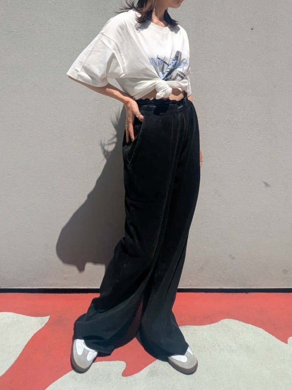 ブラック系のスウェットパンツ、ホワイト系のTシャツ/カットソーを着用したレディースの夏コーディネートの2枚目の写真