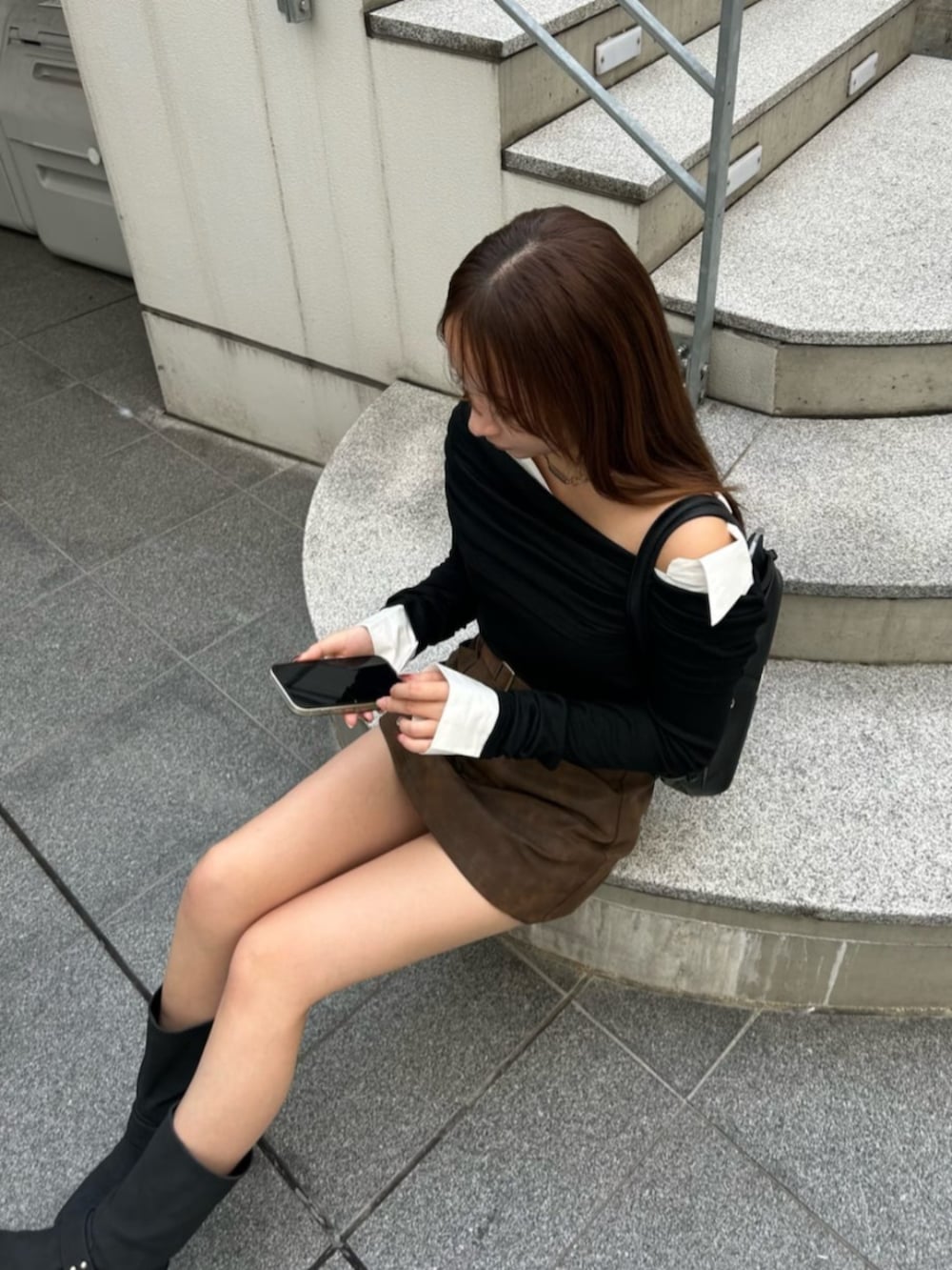 ブラック系のブーツ、ベージュ系のスカート、ブラック系のTシャツ/カットソーを着用したレディースの秋コーディネートの2枚目の写真