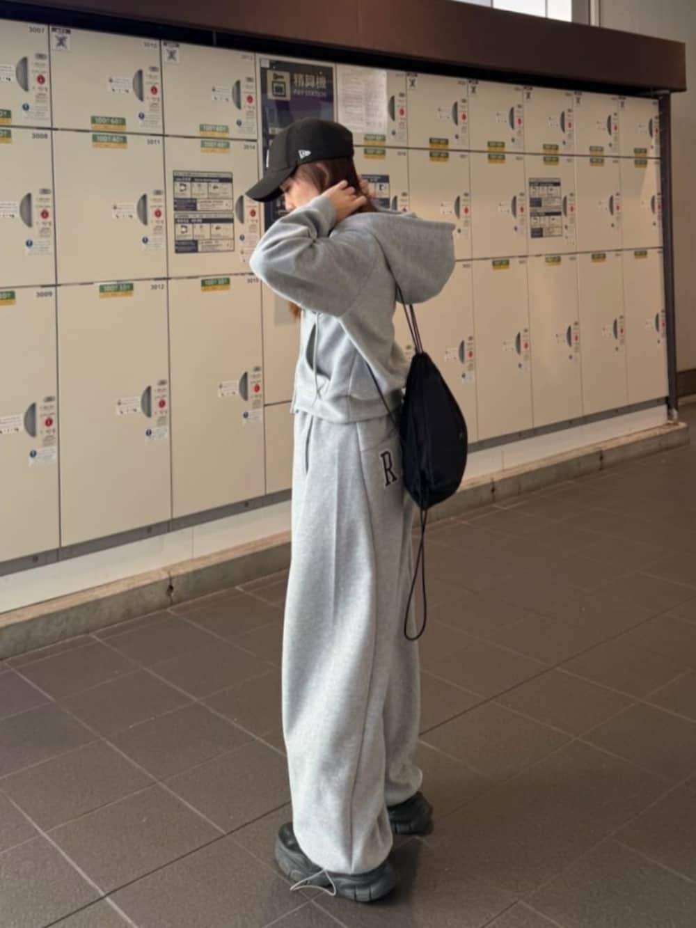 グレー系のスウェットパンツ、グレー系のパーカーを着用したレディースの冬コーディネートの2枚目の写真